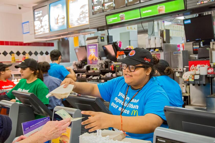 Chicago, Illinois - A young woman waits on a customer at a McDonald's fast food restaurant at Midway Airport.