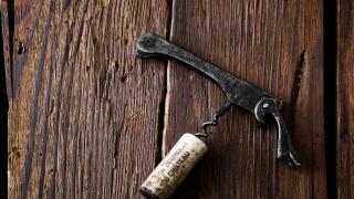 cork and corkscrew on a rustic wooden background