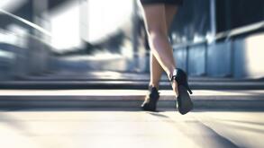 Woman running away or walking fast with high heels in city street. Busy business person in hurry. Late from work or stress fast. Sprint stairs.