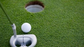 A very short putt in the game of golf on a putting green at a golf course with copy space