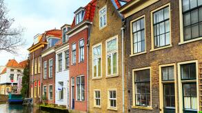 street view with traditional dutch houses, canal in downtown of popular Holland destination Delft, Netherlands