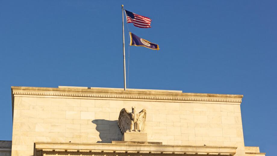 United States Federal Reserve headquarters in Washington DC, USA. Eccles Building with US National and Fed flags under clear sky in early morning.