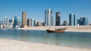 Traditional boat with modern skyline, Emirate of Sharjah, UAE.