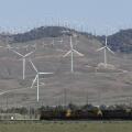 Tehachapi, CA. April 30, 2017. A cargo train passes beneath windmills in the Tehachapi Wind Resource Area, California's largest wind energy farm.