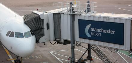 Civil aviation. Commercial air transport. Passenger jet plane connected to its jetbridge on the ramp or apron at Manchester Airport, UK