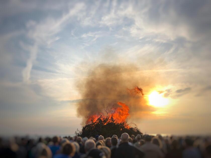 People watching a bonfire on the beach at midsummer, Fanoe, Denmark