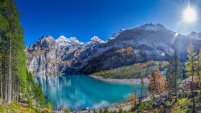 Amazing tourquise Oeschinnensee with waterfalls, wooden chalet and Swiss Alps, Berner Oberland, Switzerland.