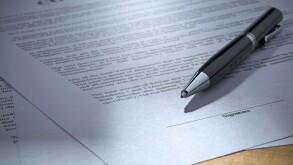 Close up of a pen over a contract to be signed.