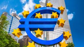 Euro sign at European Central Bank headquarters in Frankfurt, Germany with dark dramatic clouds symbolizing a financial crisis