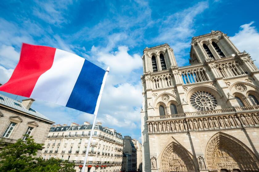French flag flying in front of Notre Dame Cathedral in Paris, France