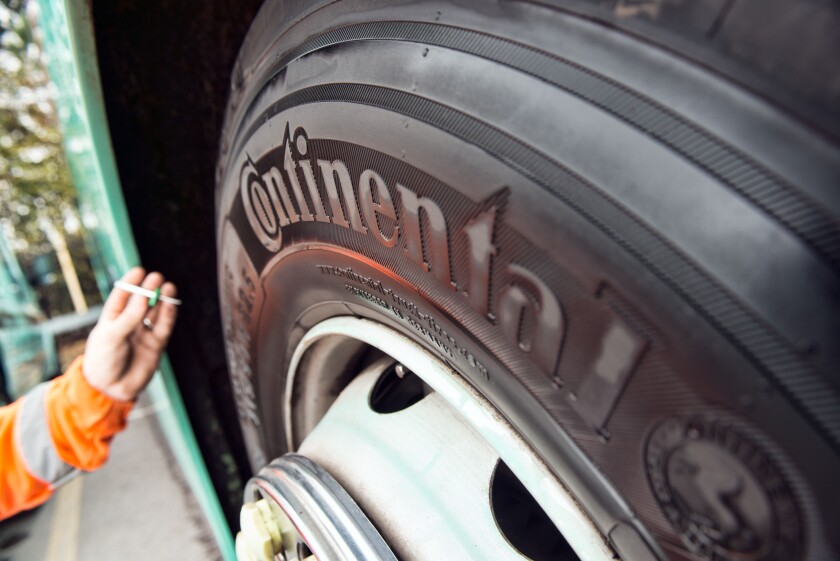 A mobile mechanic / tyre fitter checks a coaches continental tire for tread depth during a regular service & safety inspection