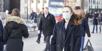 Young woman wearing face mask while walking in the streets of London