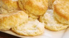 Homemade baked Southern USA buttermilk biscuits with melted butter on the ones that are sliced.