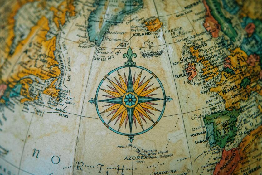 Close-up of a vintage globe showing Europe and the North Atlantic with a detailed compass rose.