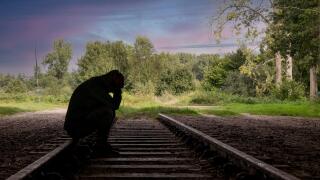 man sitting on a railway track