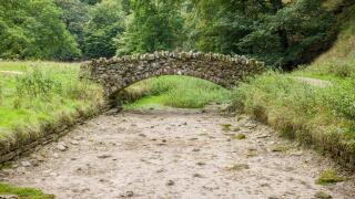 Stone bridge over a dried up riverbed. Drought in Seven Bridges Valley, North Yorkshire, England, UK