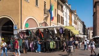 Market Italy, view in summer of the busy morning market sited in the Piazza delle Erbe in the scenic Renaissance era city of Mantua (Mantova), Italy