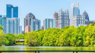 Atlanta, USA - April 20, 2018: Cityscape skyline view in Piedmont Park in Georgia downtown green trees, scenic urban city skyscrapers with railing in