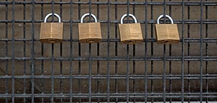 Four Master padlocks on a grill.