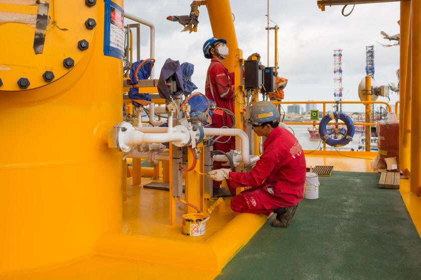 Man painting an oil rig