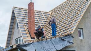 Male carpenters repair the roof of the house.
