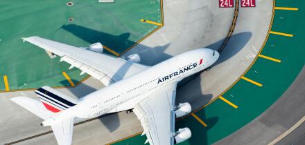Aerial view of Air France Airbus A380-800 registered as F-HPJA with international airport colorful taxiway marks and lines. Aircraft entering runway.