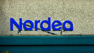 A prominent blue sign displays the name of the bank, Nordea, on the exterior of a well-maintained building, emphasizing its modern design and accessib