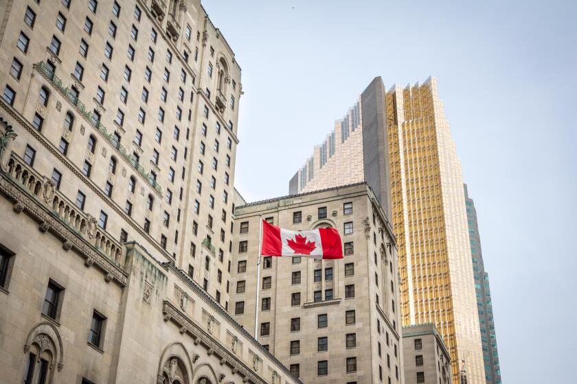 Canadian flag in front of a business building and an older skyscraper in Toronto, Ontario, Canada

Old and new buildings seen from the ground with a c