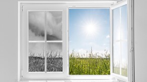 Half open window with view to the outside half on gray storm and half on clouds in blue sky with sun