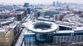 Brussels, Belgium - 8 February 2021: Aerial view of a European Union building under the snow at wintertime near Parque du Cinquantenaire.