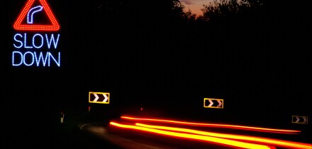 dangerous drive and speeding at night on the hairpin bend road. Slow DOWN sign