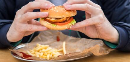 close up view of man's hands with american burger.