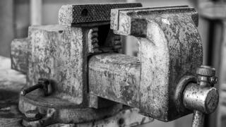 Old rusty vise for working, securing by tightening and machining metal and parts