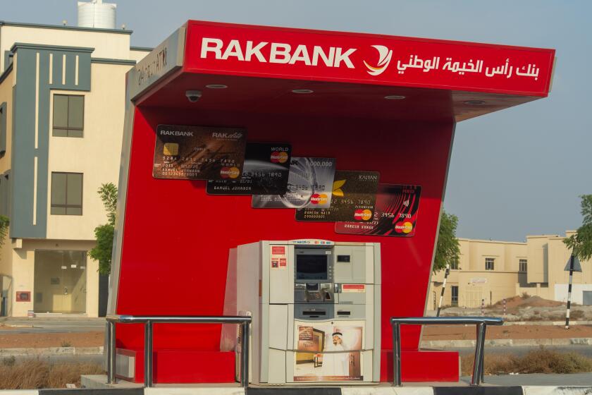 "Ras al Khaimah, RAK/ United Arab Emirates - 10/10/2019: RAK Bank red logo atm sign in evening on a main road in the northern Emriates"