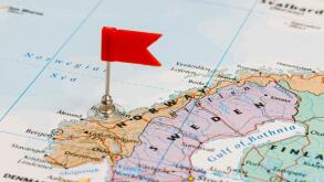 Photo of Norway marked by red flag in holder. Country on European continent.