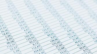 Business data report selective focus close up. Monthly stock stats spreadsheet. Blue toned.