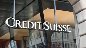 Credit Suisse bank logo created with big white letters is placed on modern building.