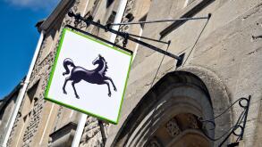 The Lloyds bank black horse sign hanging, displayed over the entrance,outside a UK branch on a sunny day