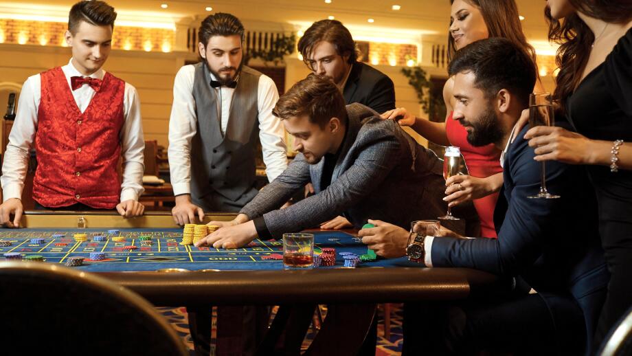 A group of people playing gambling in a casino.