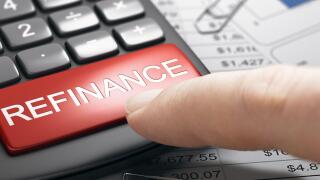 Finger about to press a red button on a conceptual refinance calculator. Concept of bad credit repair. Composite image between a hand photography and