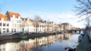Dutch canal with old houses and boats with blue sky