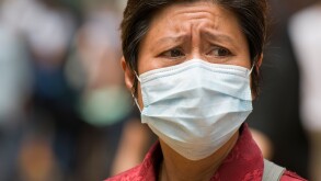 A woman wearing a surgical mask as protection against swine flu Hong Kong May 2009