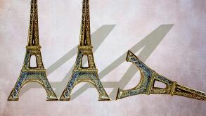 Three miniature Eiffel Towers shaped like the letter A, one toppled over, symbolic image for the French AAA credit rating