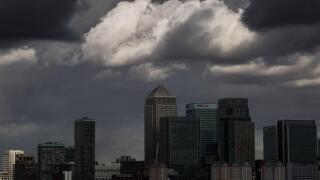 Dark storm clouds over Canary Wharf business park buildings in London