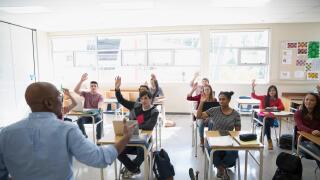 High school teacher calling students with hand raised