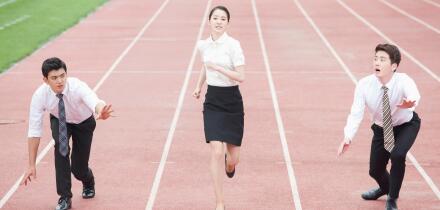 Business people racing on tracks at stadium