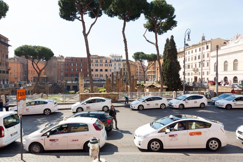 Taxi cars parked in street in Rome, Italy