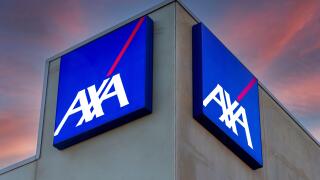 Fossano, Italy - February 22, 2022: Axa logo on illuminated signs on building on colorful after sunset sky,  Axa is French insurance and bank services