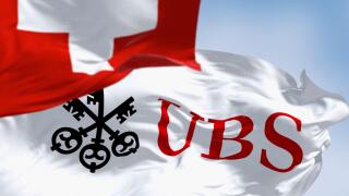Zurich, CH, Oct. 10 2023: Flags of Switzerland and UBS fluttering in the wind on a clear day. Finance and banking. In March 2023, UBS bought Credit Su