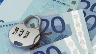 Combination padlock rests on Twenty Euro banknotes